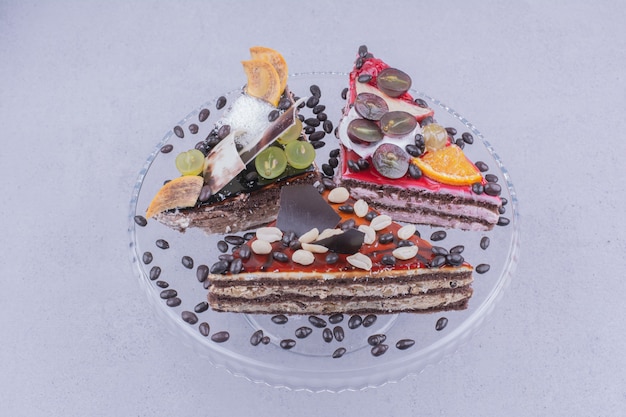 Fatias de bolo triangular com chocolate e frutas em uma travessa de vidro