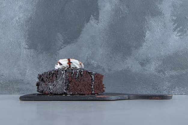 Fatias de brownie de chocolate saboroso com creme na tábua. foto de alta qualidade