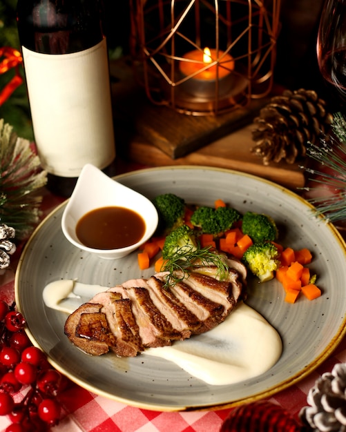 Fatias de carne frita servidas com creme de cenoura e molho de brócolis