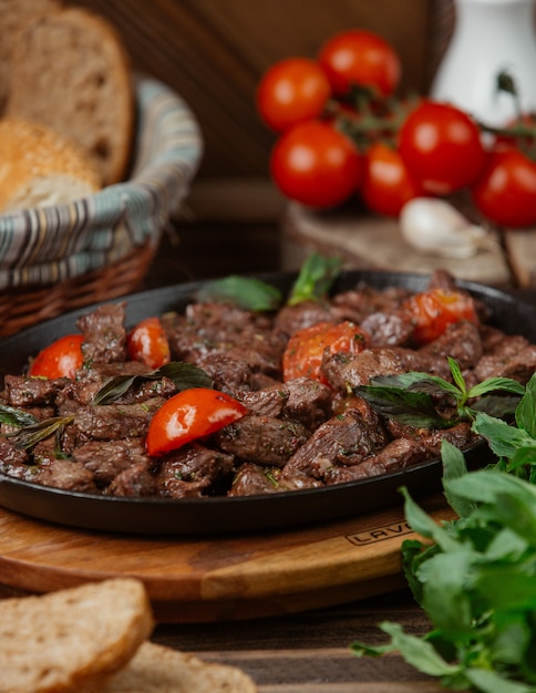 Fatias de carne marinadas, guarnecidas com estragão e tomate