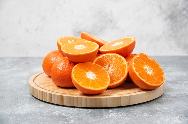 Fatias de frutas suculentas de laranja frescas em uma placa de madeira.