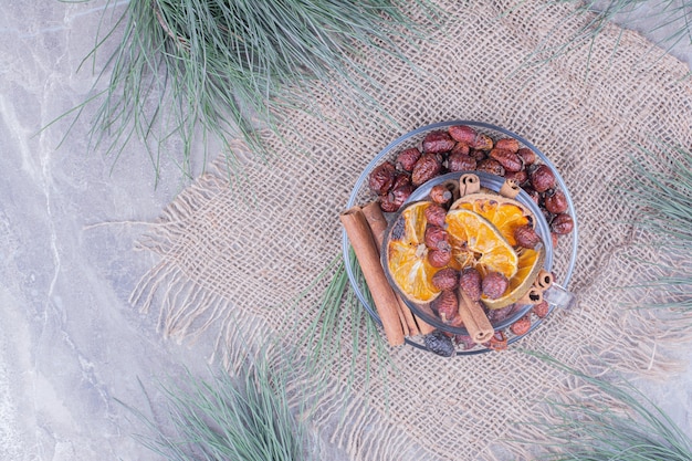 Fatias de laranja secas com canela e quadris em um copo de vidro