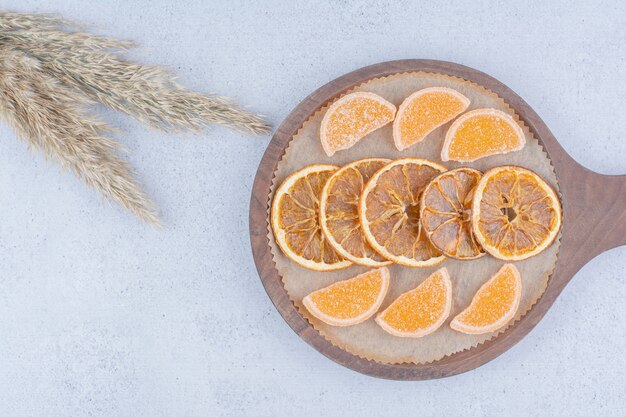 Fatias de laranja secas e marmeladas na placa de madeira.