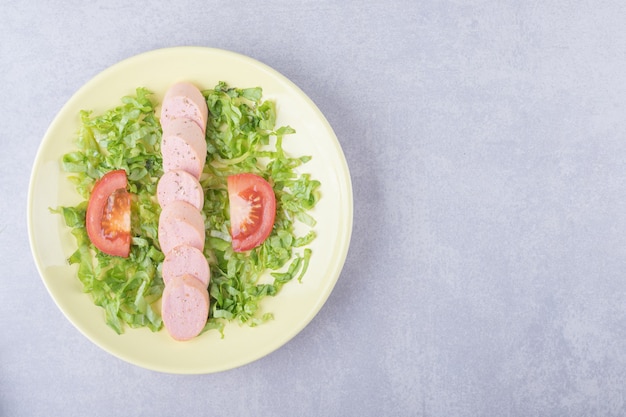 Fatias de linguiça e tomate na placa amarela.