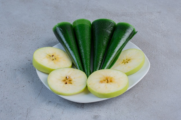 Fatias de maçã e lanche azedo com sabor de maçã em uma bandeja no fundo de mármore.