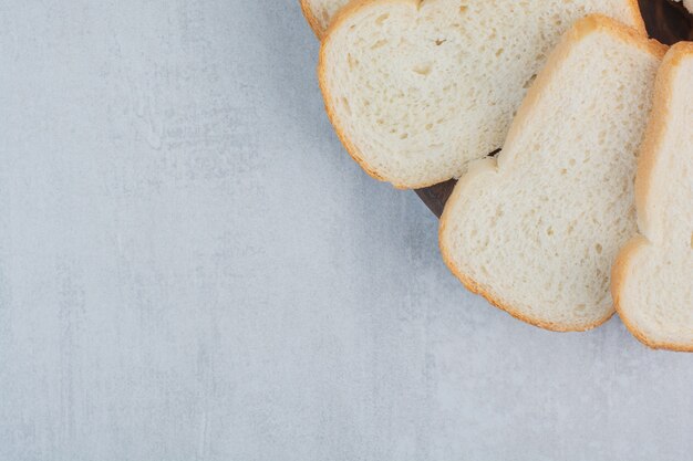 Fatias de pães brancos frescos em fundo de mármore.