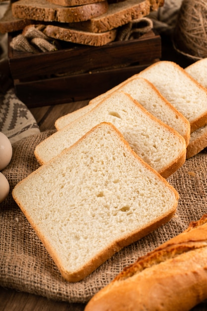 Fatias de pão branco e escuro na caixa e na toalha de mesa