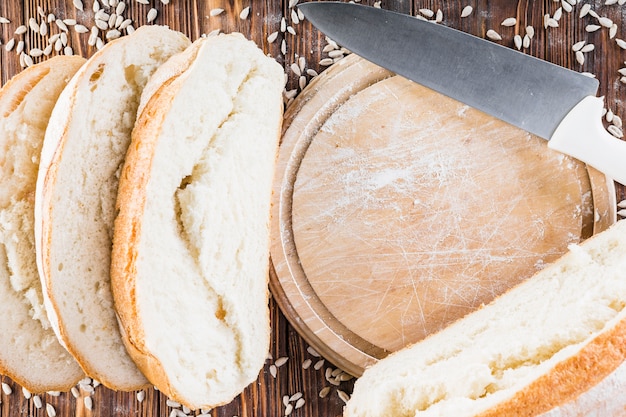 Fatias de pão e tábua de cortar com faca