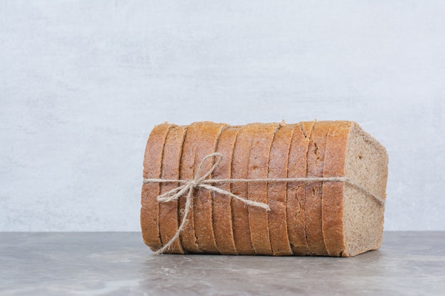 Fatias de pão integral em corda na superfície de mármore