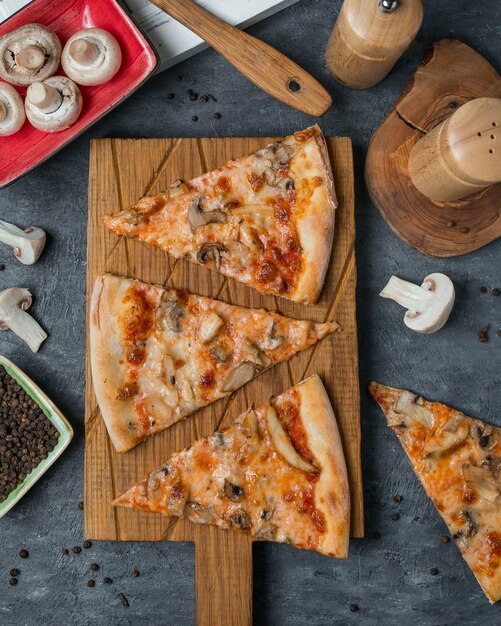 Fatias de pizza em uma placa de madeira de bambu