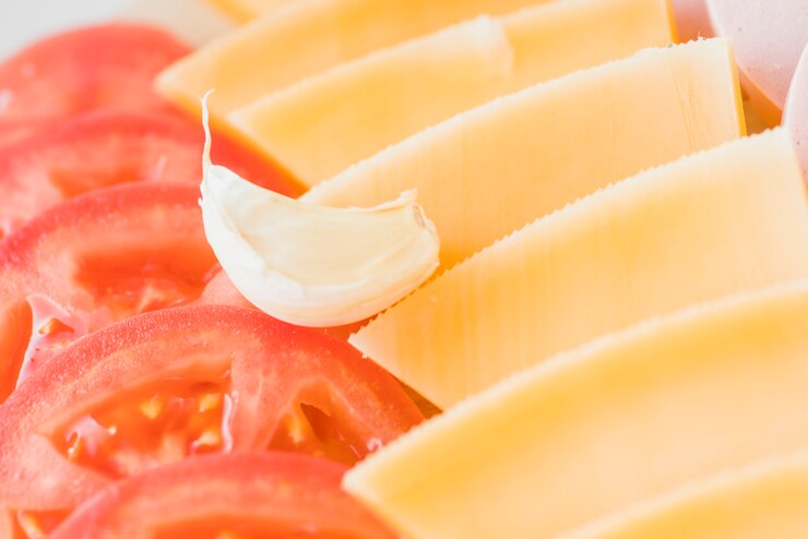 Foto grátis fatias de queijo perto de tomate