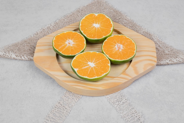 Fatias de tangerinas frescas na placa de madeira. Foto de alta qualidade