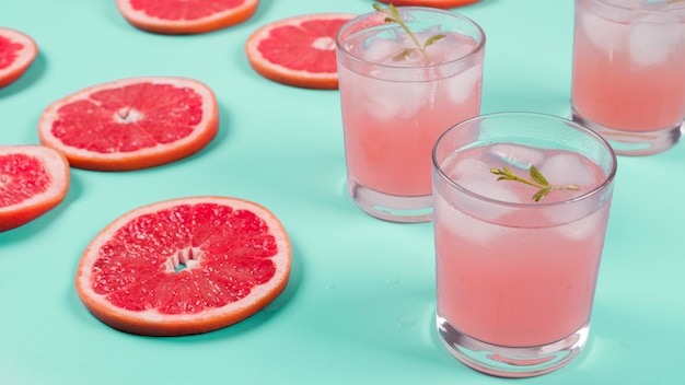 Fatias de toranja vermelha e suco de cocktail no fundo de hortelã