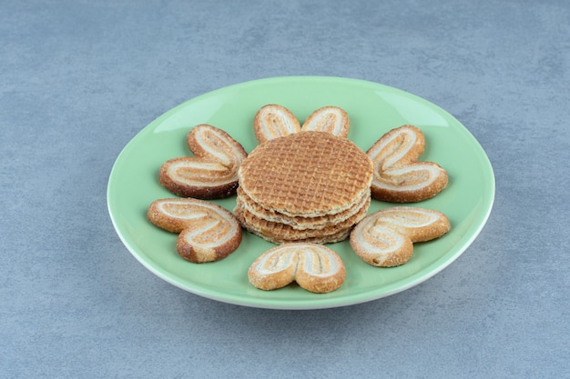 Fatias de waffle com biscoitos na placa verde.