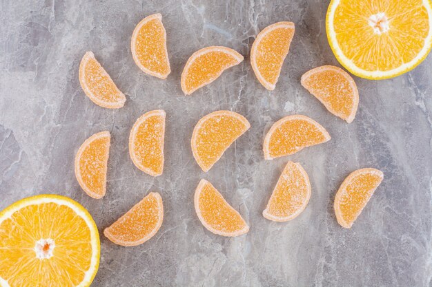 Fatias frescas de laranja com geleias em fundo de mármore.