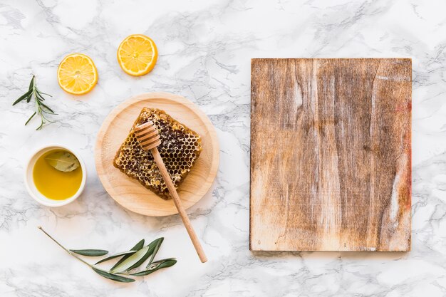 Foto grátis favo de mel com azeite de oliva com tábua de madeira