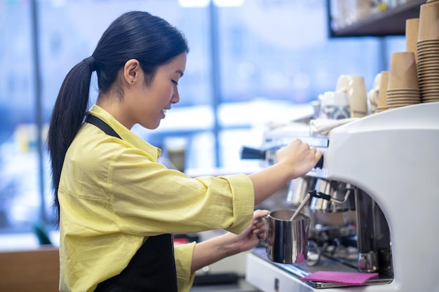 Fazendo café. Barista fazendo café e mexendo o leite