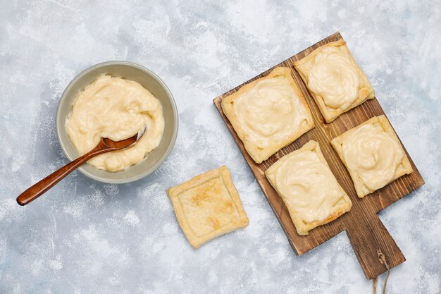 Foto grátis fazer massa folhada deliciosa deliciosa com creme de leite no concreto, vista superior