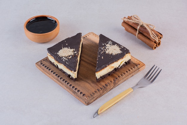 Foto grátis fechar foto de fatias de bolo de chocolate fresco com canela e garfo sobre cinza