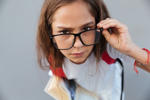 Fechar o retrato da calma morena colegial em óculos