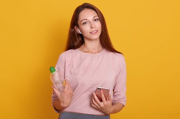 Fechar o retrato de mulher desportiva ajuste vestindo camisa rosada