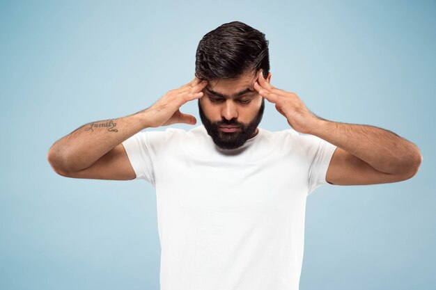 fechar o retrato de um jovem indiano de camisa branca. Concentrando-se, sofrendo de dor de cabeça.