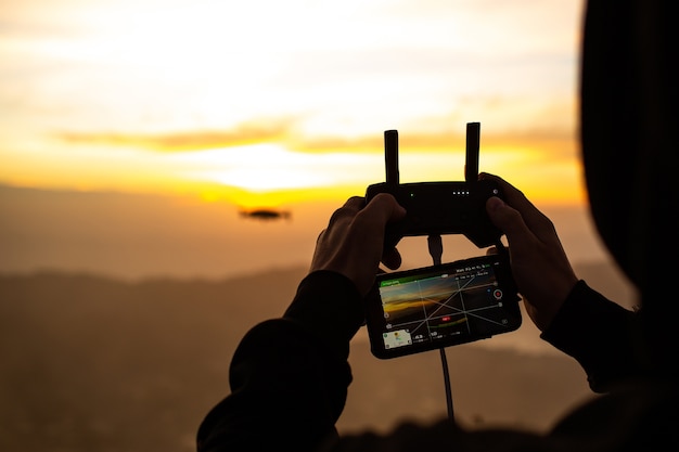 Fechar-se. Um homem controla um drone ao sol do amanhecer no vulcão BATUR. Bali, Indonésia