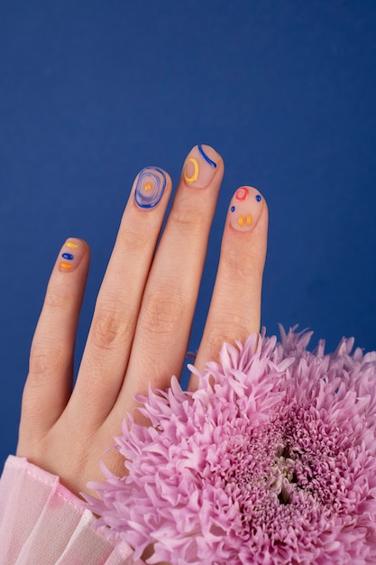 Foto grátis feche a bela manicure e flor roxa