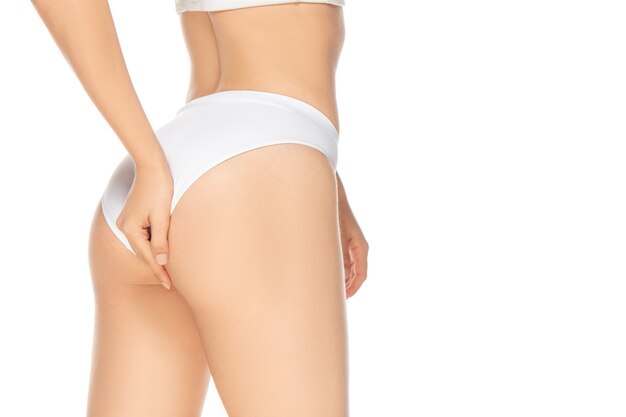 Feche a bela modelo feminino isolado no fundo branco. Beleza, cosméticos, spa, depilação, dieta e tratamento, conceito de fitness. Fit e esportivo, corpo sensual com pele bem cuidada.