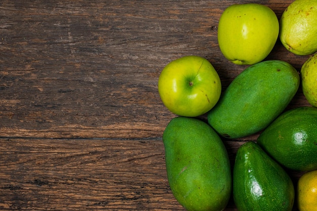 Feche a coleção de frutas verdes isoladas em uma mesa de madeira com espaços em branco para o conceito de comida de texto