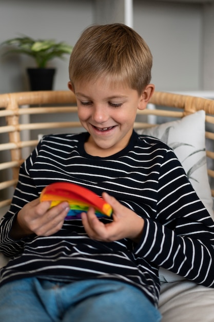 Foto grátis feche a criança brincando com o brinquedo pop-it