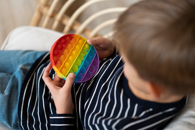 Foto grátis feche a criança brincando com o brinquedo pop-it