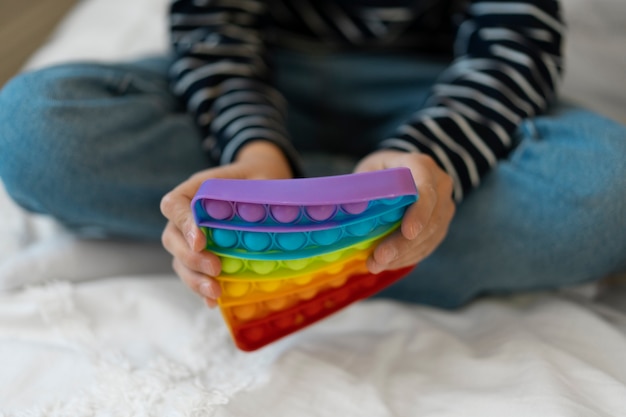 Foto grátis feche a criança brincando com o brinquedo pop-it