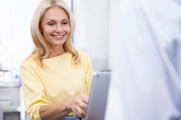 Feche a doutora sorridente com o tablet