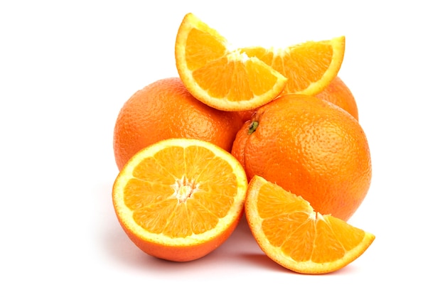 Feche a foto da pilha de laranjas inteiras ou fatiadas, isoladas na superfície branca.