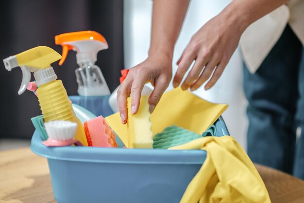 Feche a foto das mãos contando algo da caixa com material de limpeza