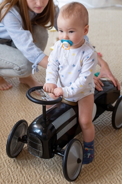 Feche a mãe e o bebê brincando