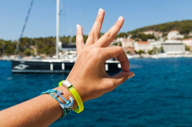 Feche a mão mostrando sinal de ok para o mar