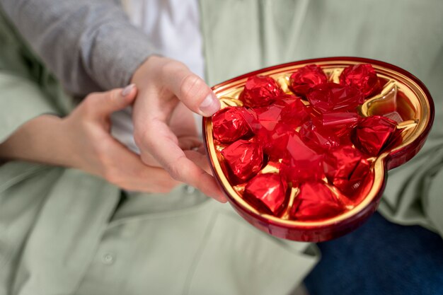 Feche a mão segurando a caixa de doces