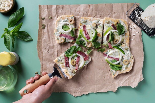 Foto grátis feche a mão segurando a espátula de pizza