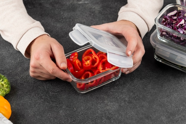 Feche a mão segurando o recipiente de comida