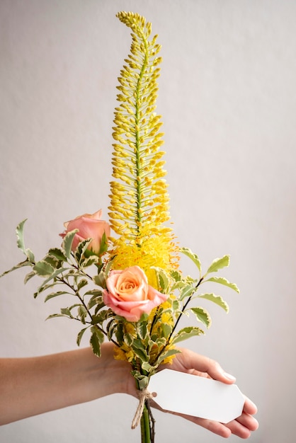 Feche a mão segurando um buquê de flores