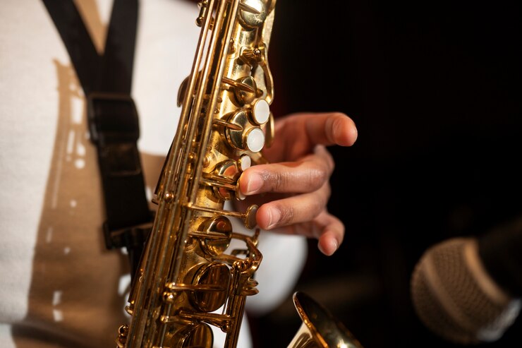 Foto grátis feche a mão tocando saxofone