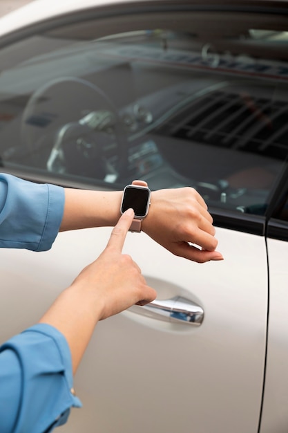 Foto grátis feche a mão usando smartwatch para destravar o carro