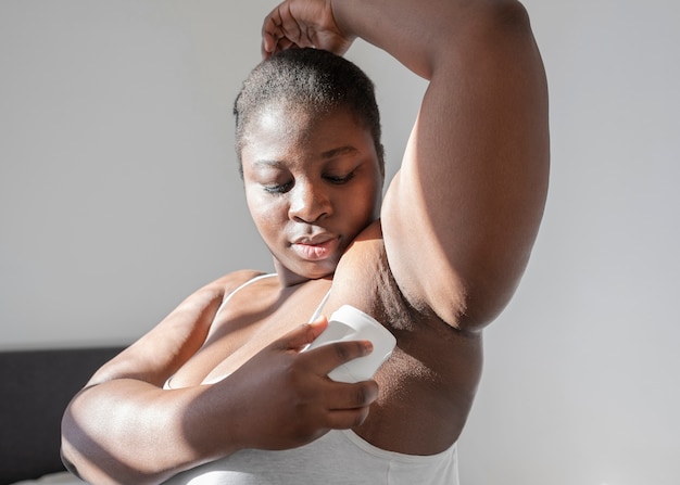 Foto grátis feche a mulher aplicando desodorante