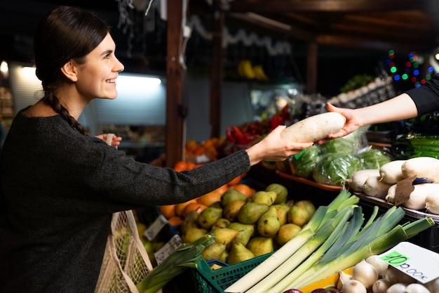 Feche a mulher comprando legumes