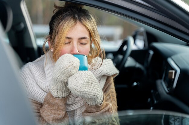 Feche a mulher desfrutando de bebida quente durante a viagem de inverno