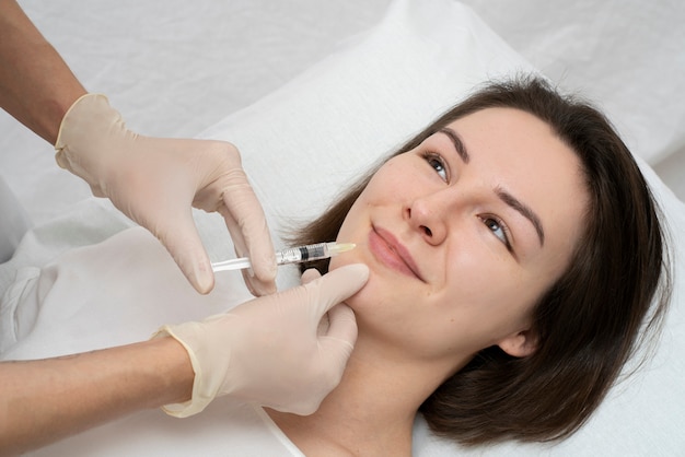 Feche a mulher durante o procedimento de preenchimento labial