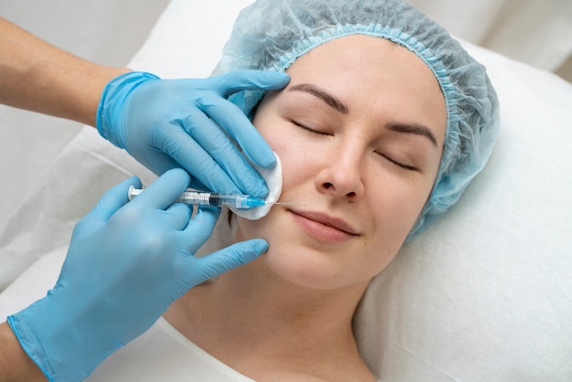 Foto grátis feche a mulher durante o procedimento de preenchimento labial