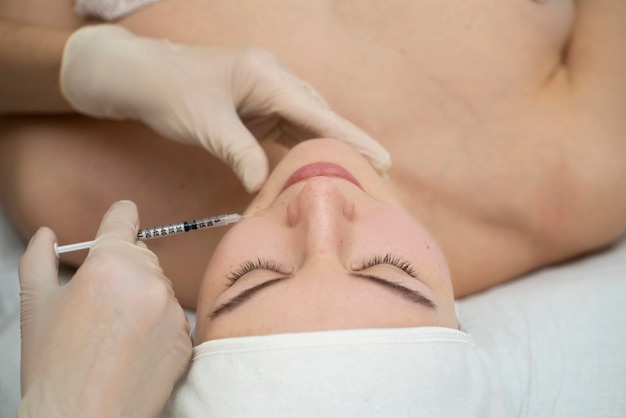 Feche a mulher durante o procedimento de preenchimento labial